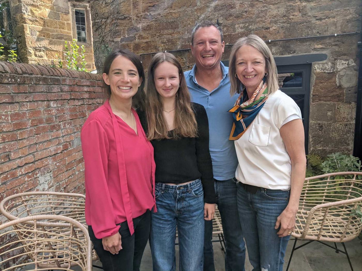 A smiling family group standing together in a garden