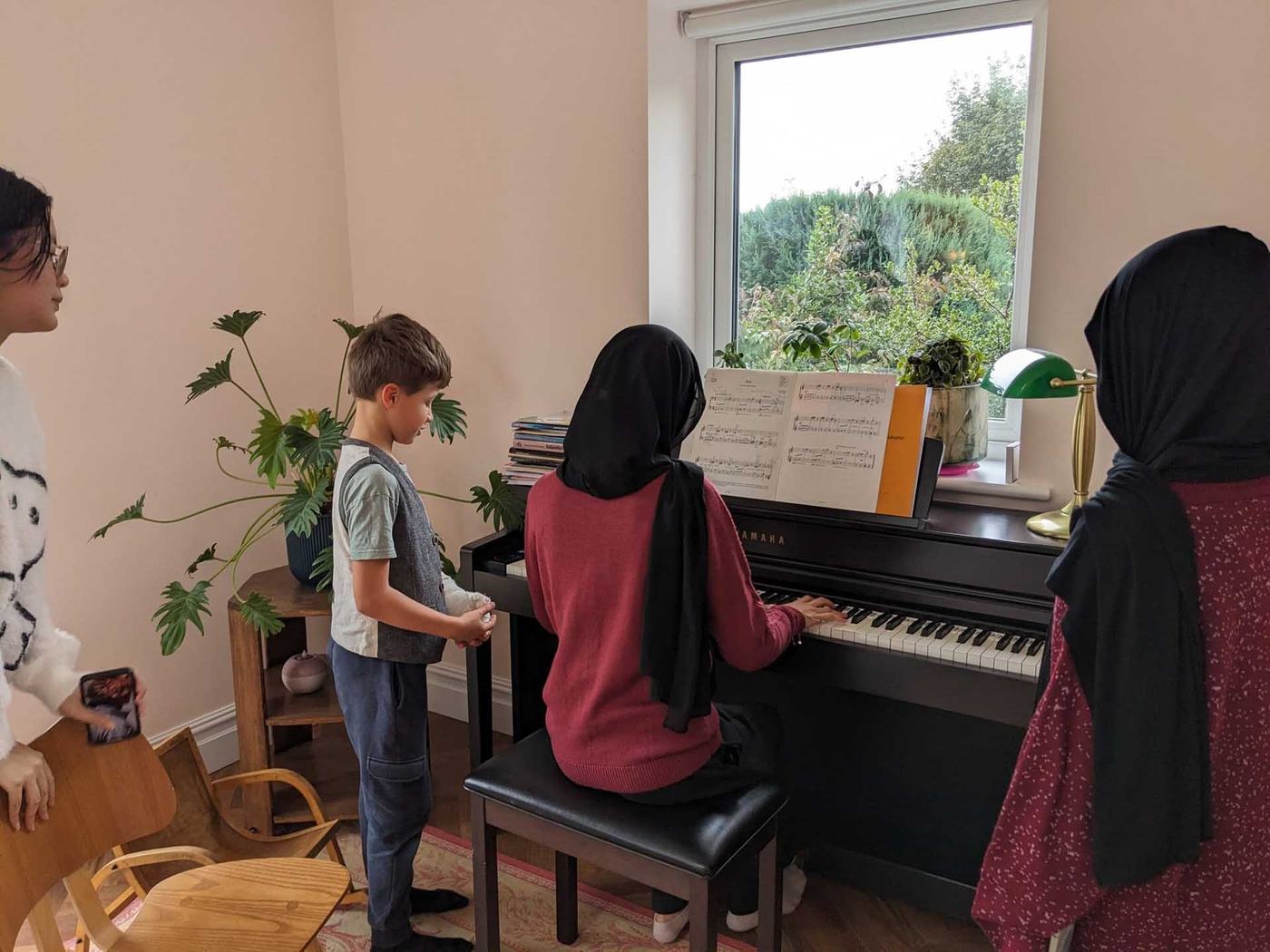 Students playing the piano in their host family home