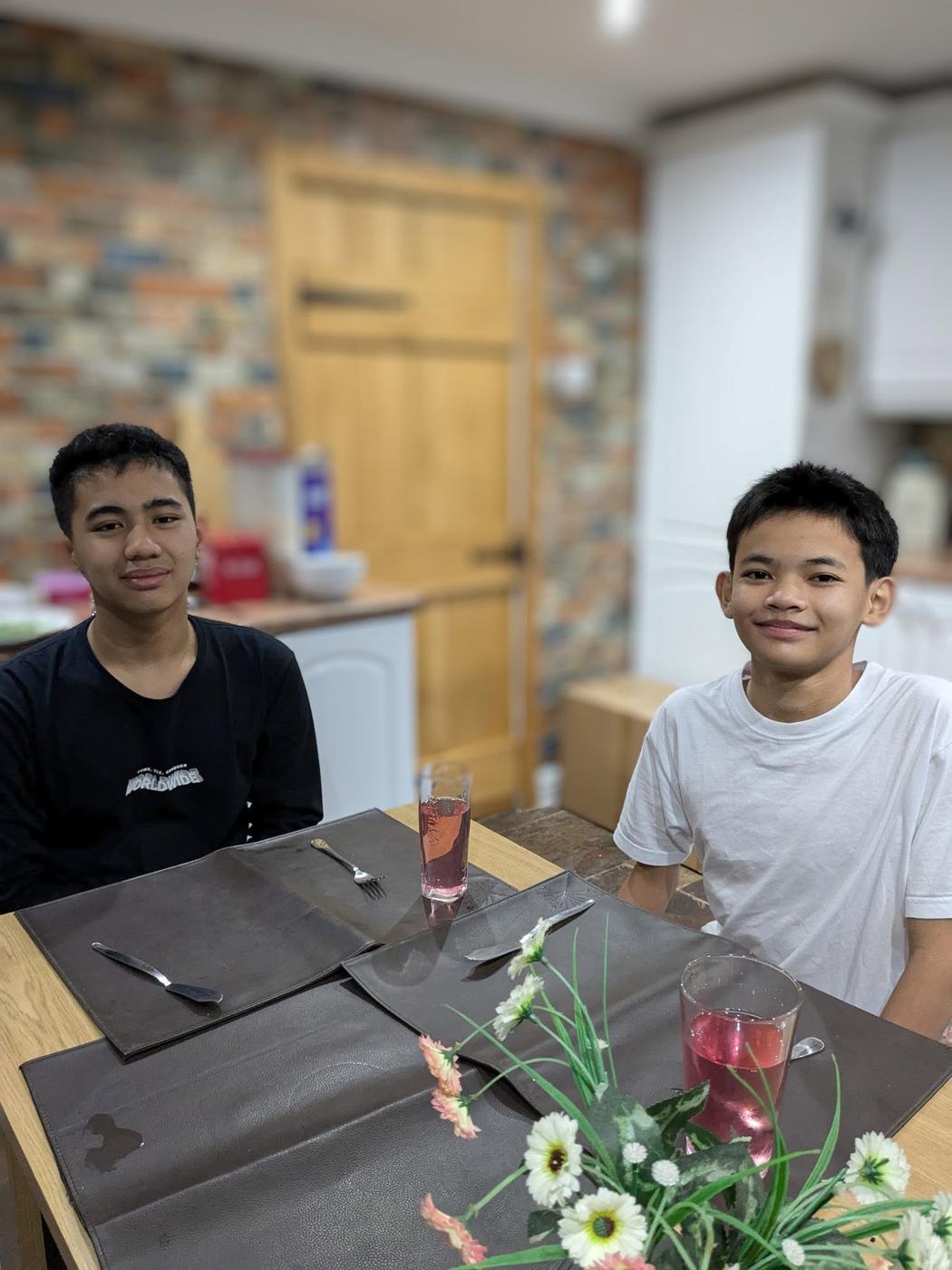 Two students at the dining table in their host family home